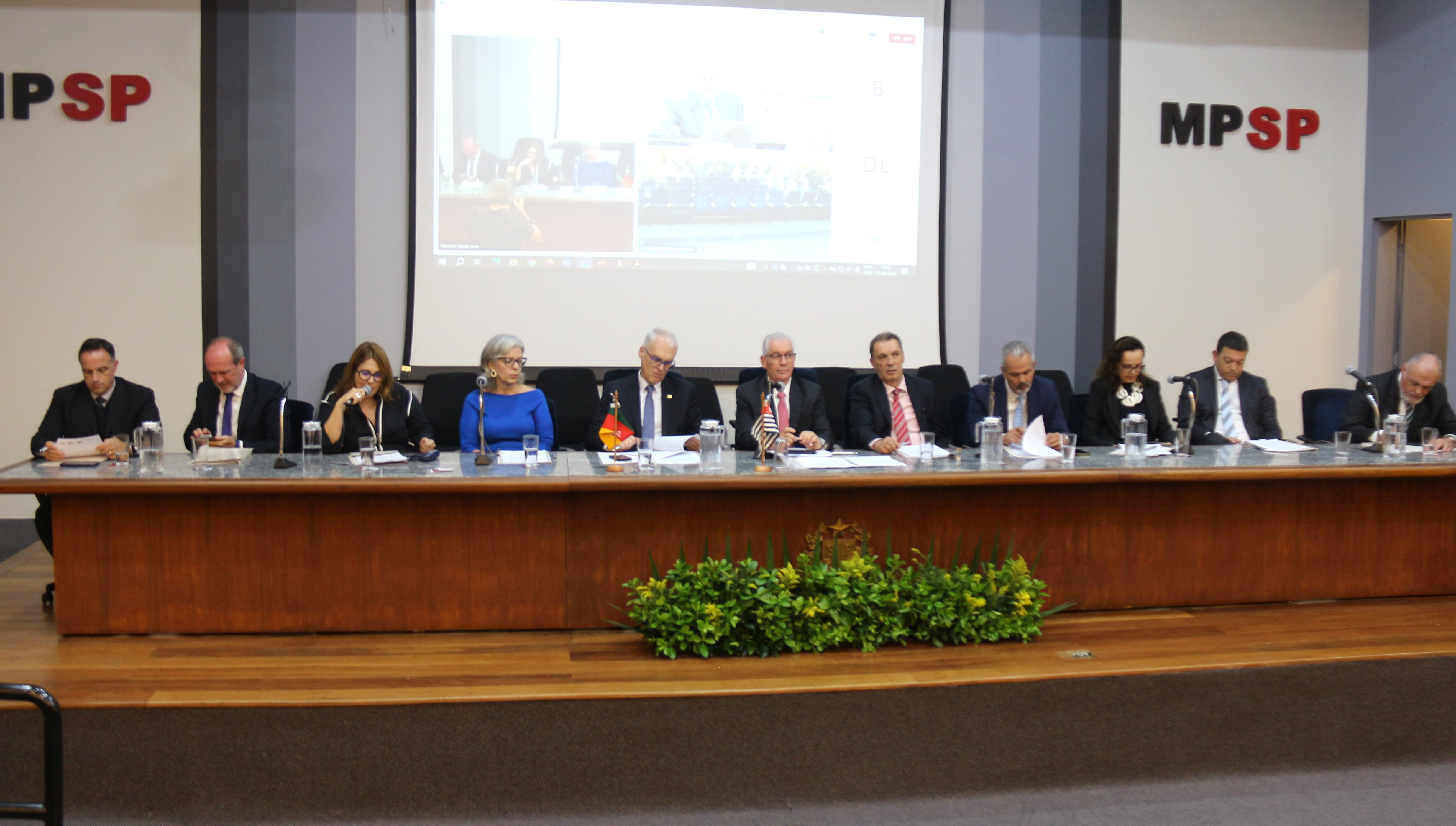 Foto dos participantes da reunião sentados à mesa durante a abertura