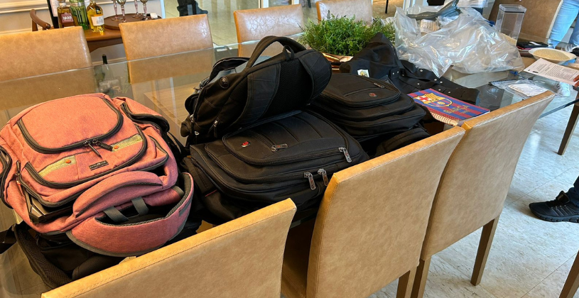 Bolsas e mochilas apreendidas sobre mesa de jantar