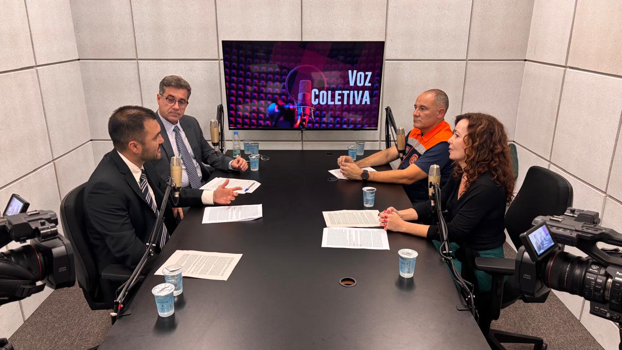 participantes do programa sentados à mesa no estúdio de videocast